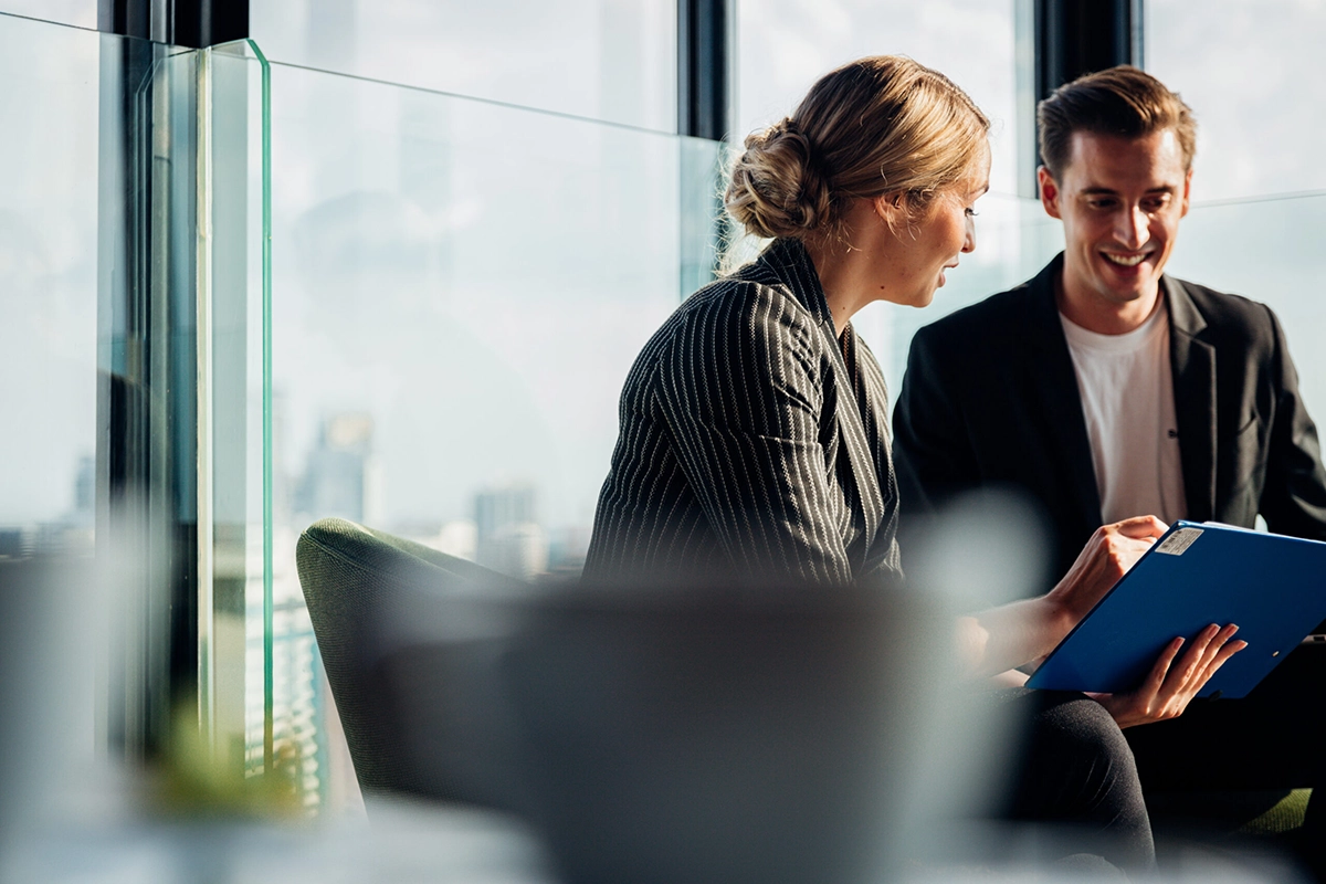 Business Consulting Meeting for Strategic Growth Business consultants reviewing documents and discussing strategic planning solutions for organizational growth.